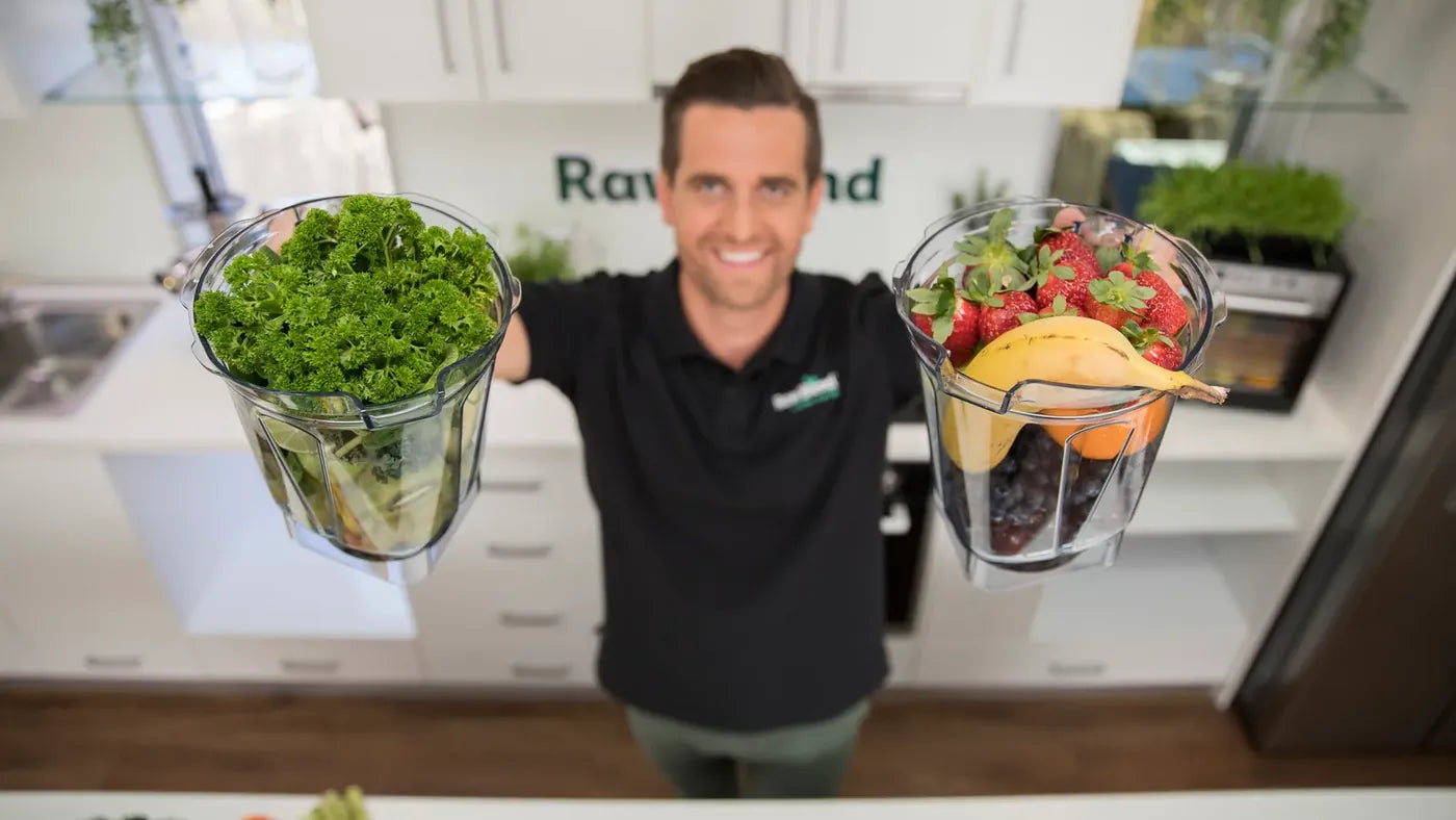 Tommy Nicholas holding Vitamix containers full of greens and berries