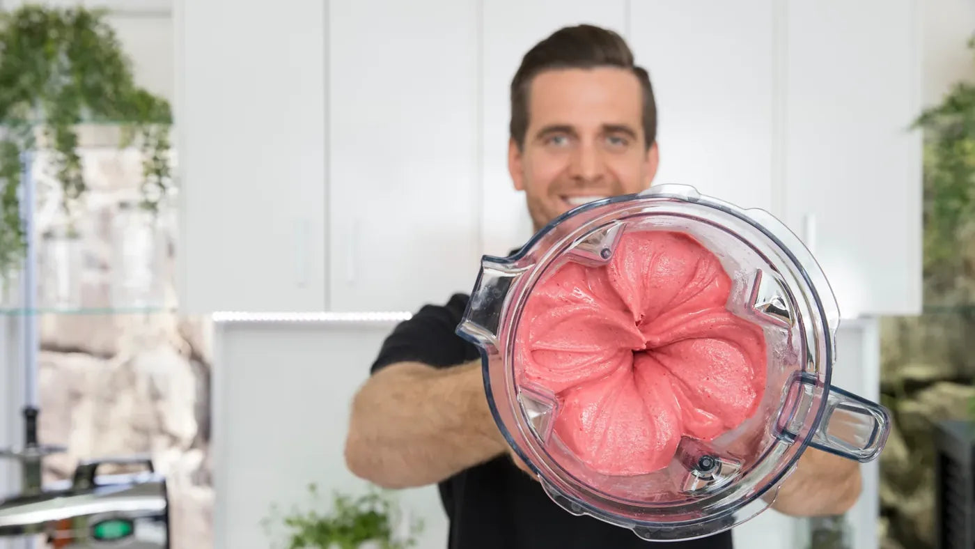 Tommy Nicholas holding a Vitamix container of berry nice cream