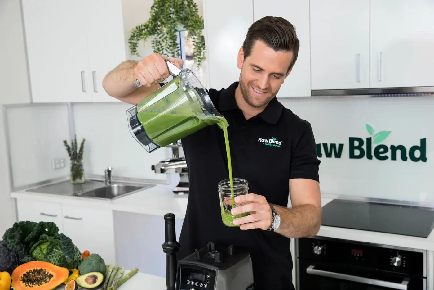 Tommy Nicholas pouring a green smoothie from a Vitamix