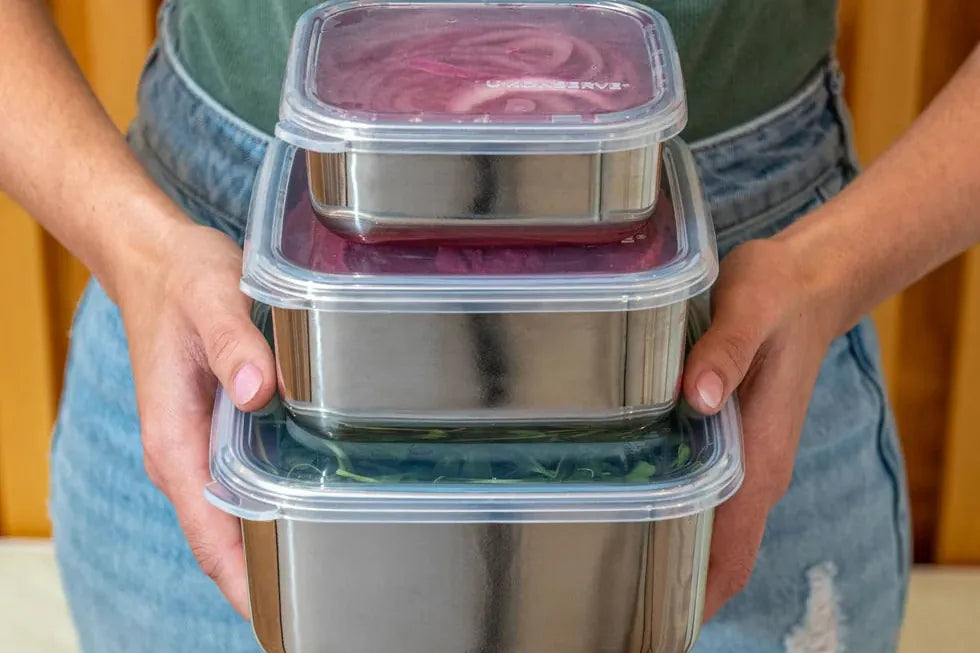 Hands holding a stack of U-Konserve stainless steel containers