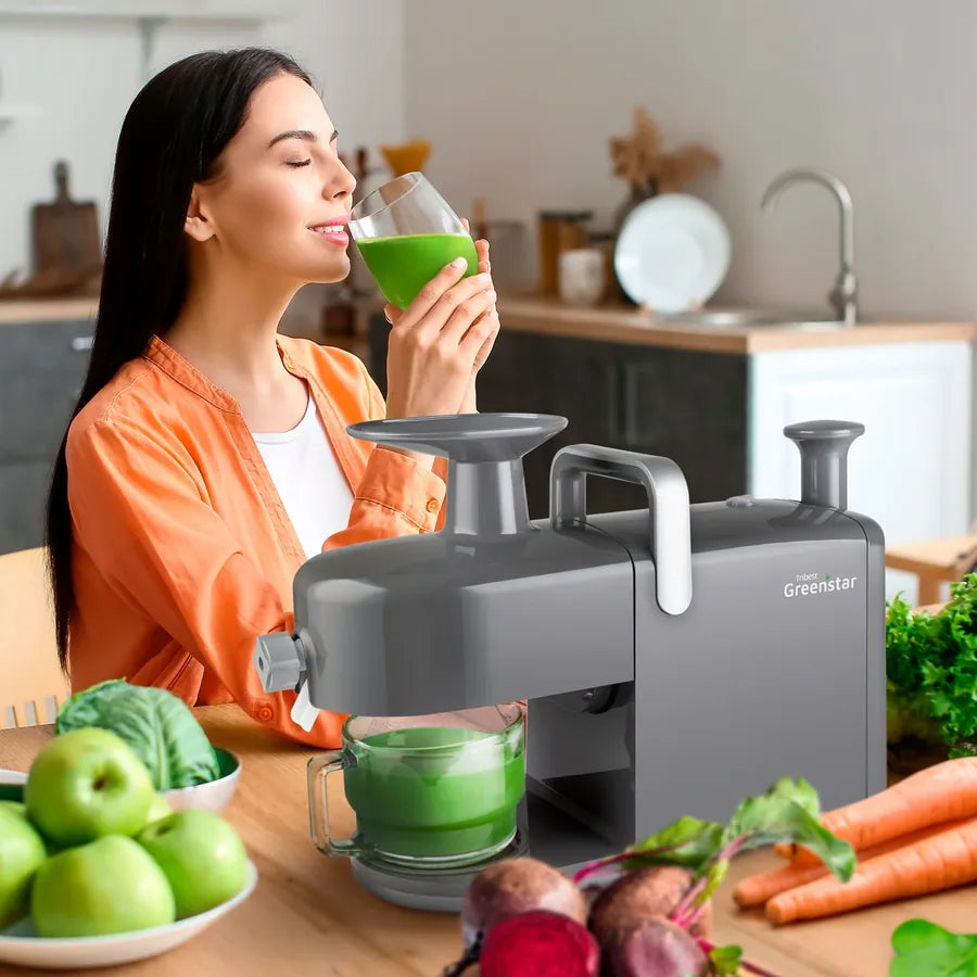 Sipping fresh green juice beside a Greenstar juicer