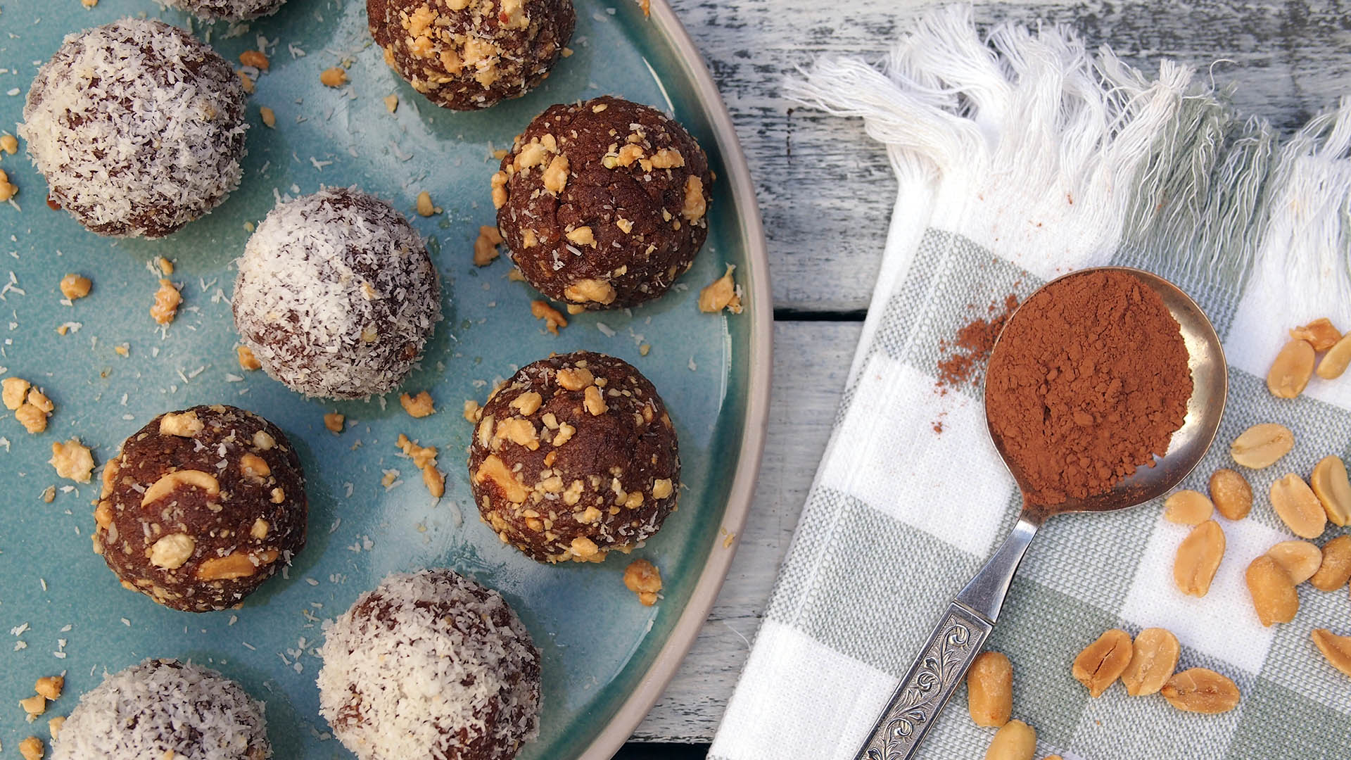 Image of Choc Peanut Butter Bliss Balls on a Plate with a Spoonful of Raw Cacao