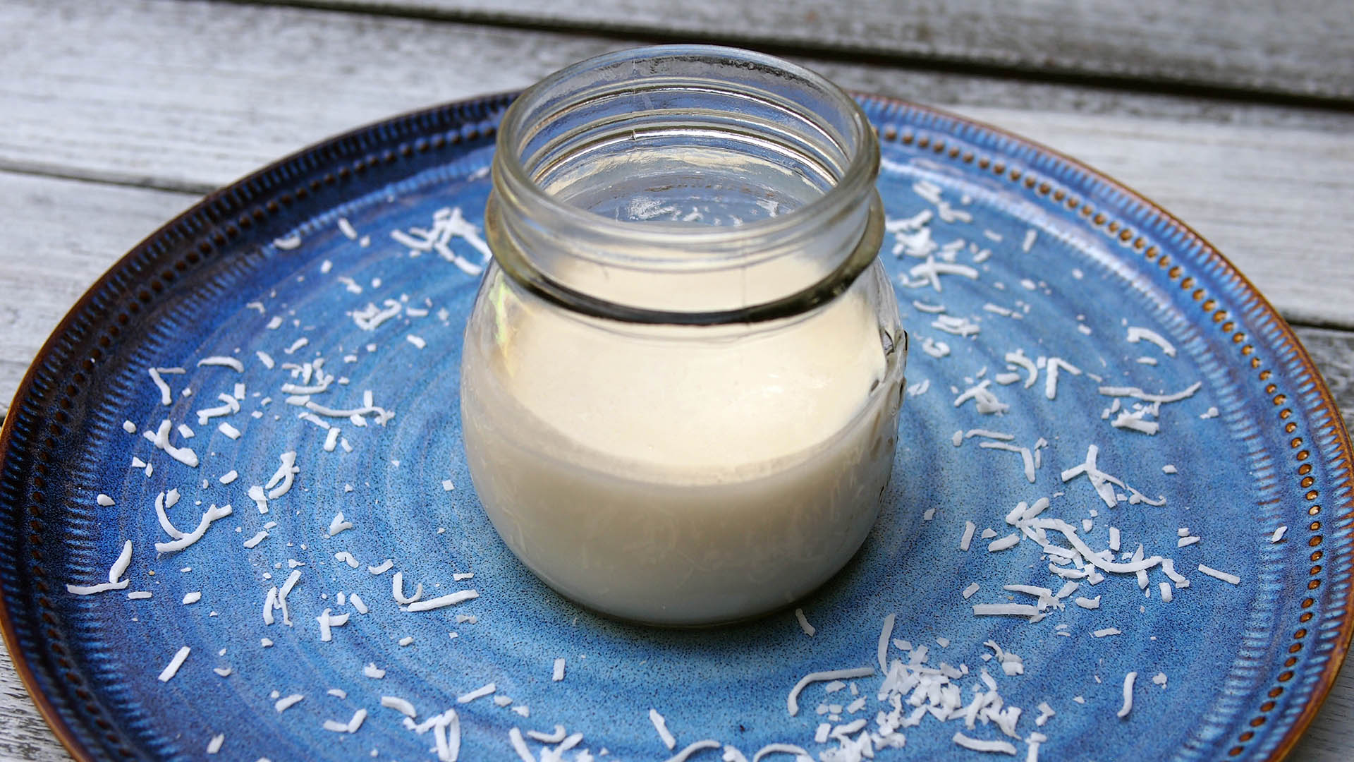 Image of Coconut Butter Recipe in a jar sitting on a blue plate