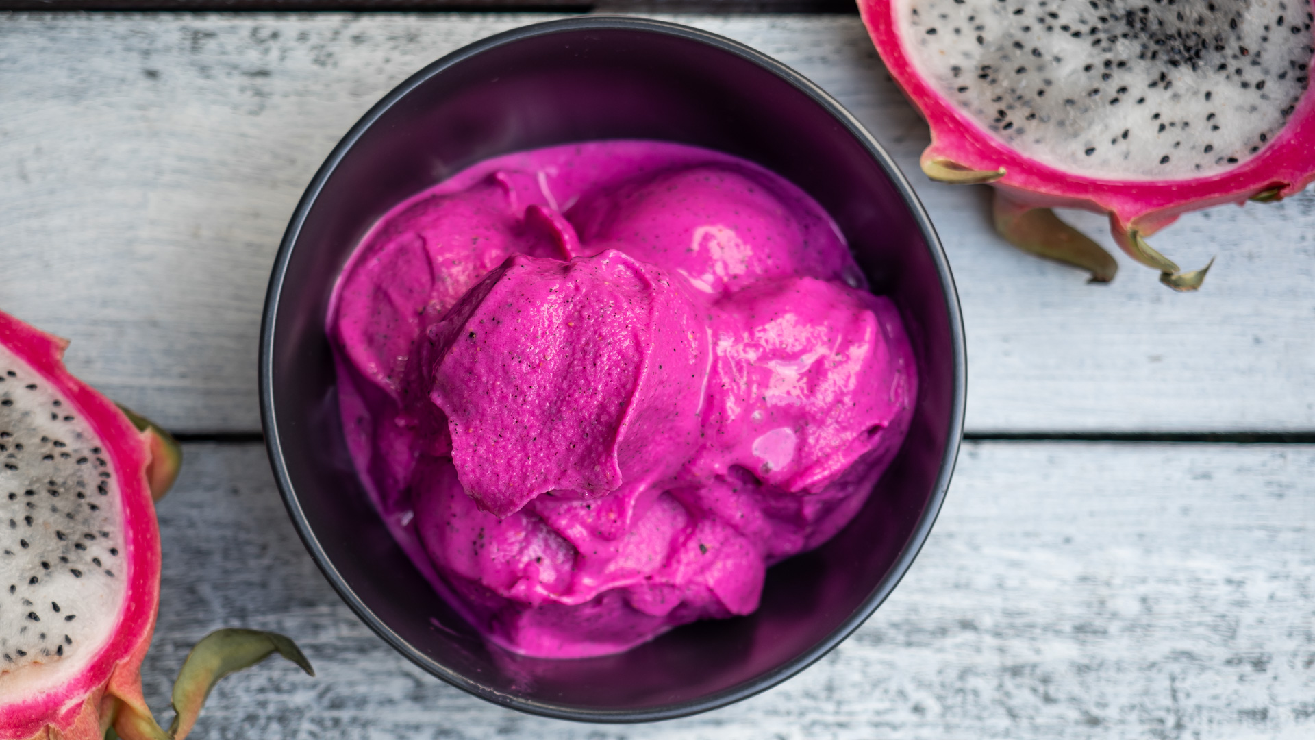 Image of a bowl of dragonfruit ice cream with a dragonfruit cut up around it
